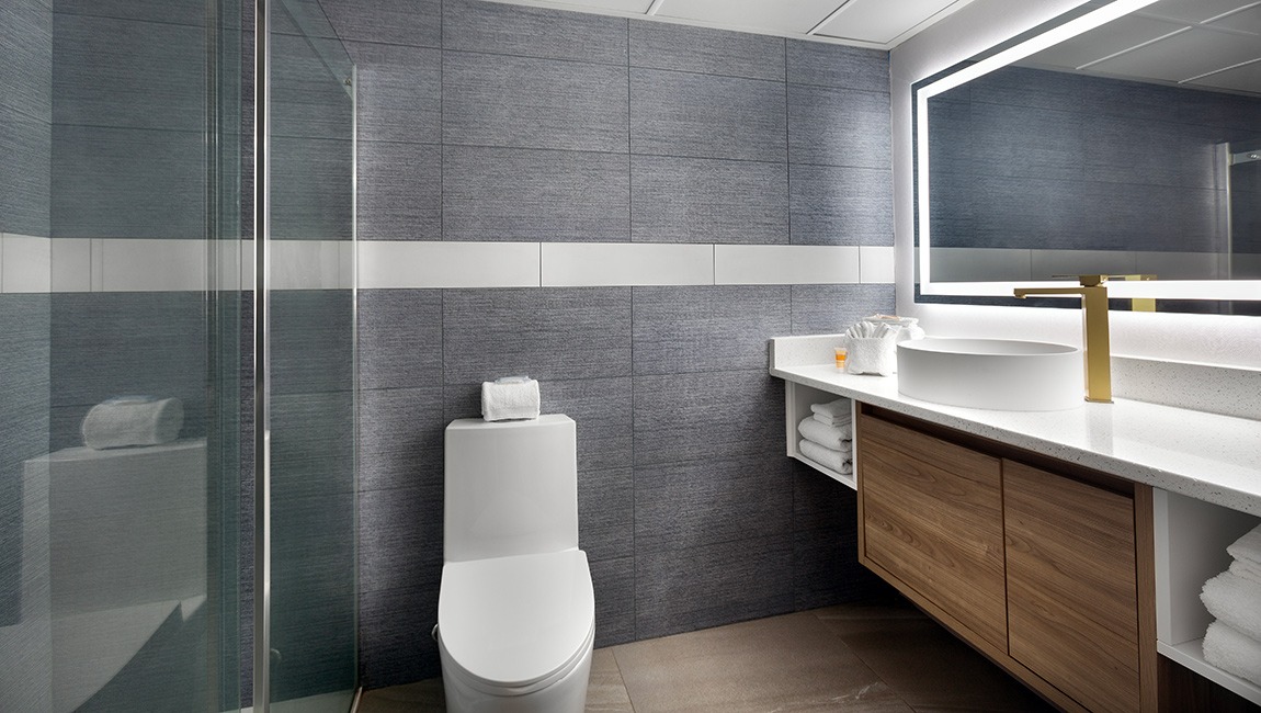 A modern bathroom with a toilet, sink, and shower.