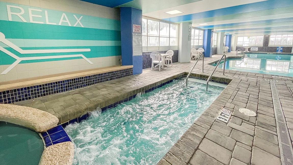 An indoor pool with a jacuzzi and a tiled floor