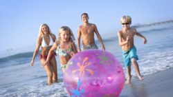 Family chasing a beach ball
