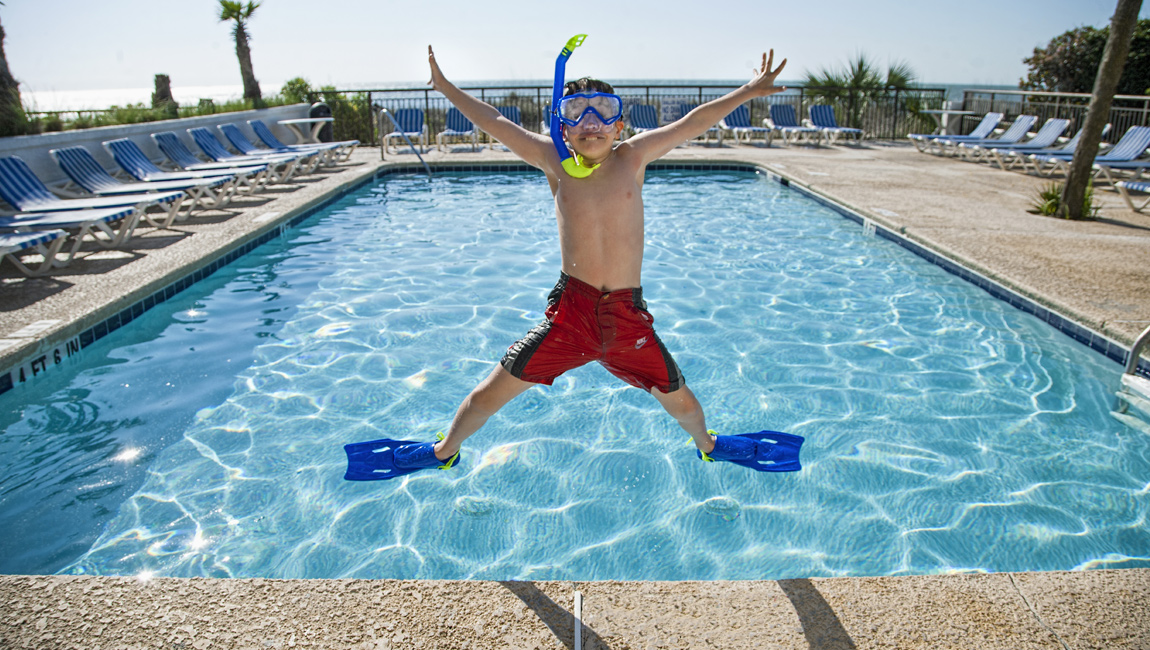 Boy jumping at the Captain's Quarters hotel pool